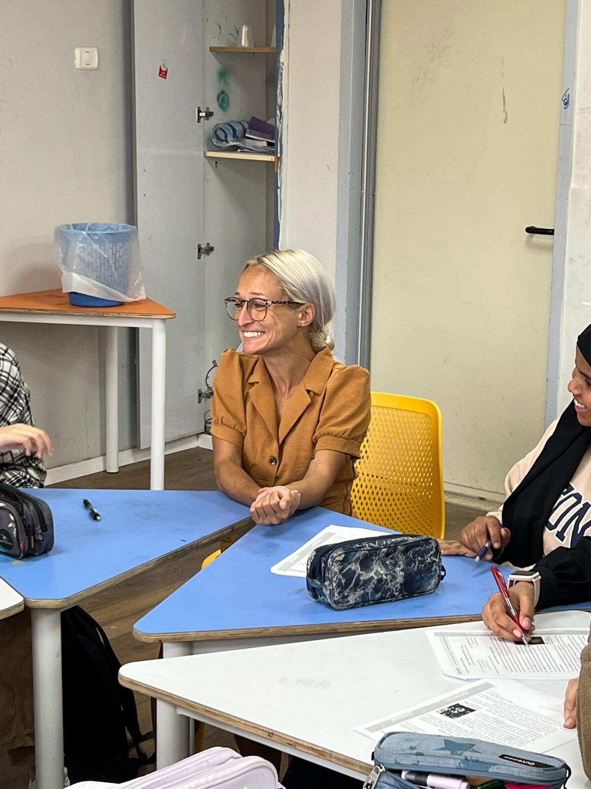 A Bridges teacher and students smiling together during a small-group lesson